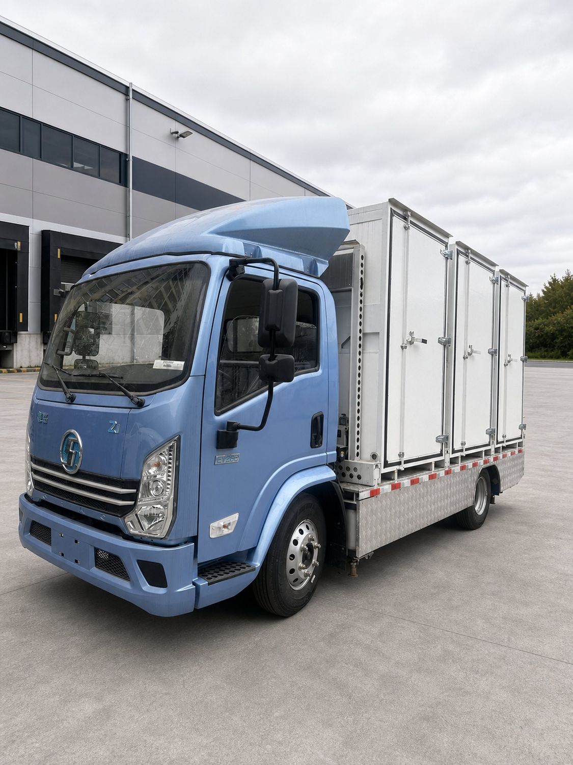 Aeroswap S6 with a blue cab and three white modules parked outside a warehouse